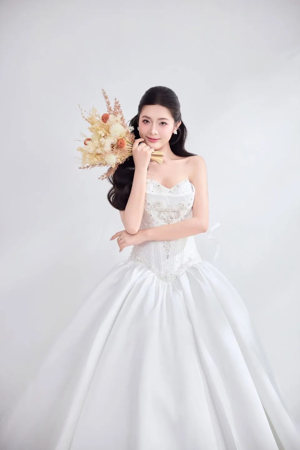 Cô dâu váy cưới cúp ngực cầm bó hoa tông cam nhạt
