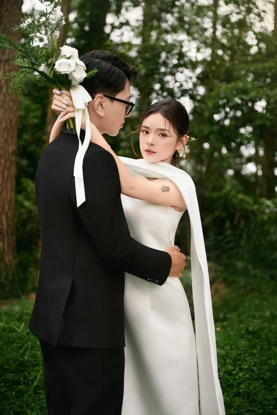 Cô dâu ôm chú rể dưới tán cây