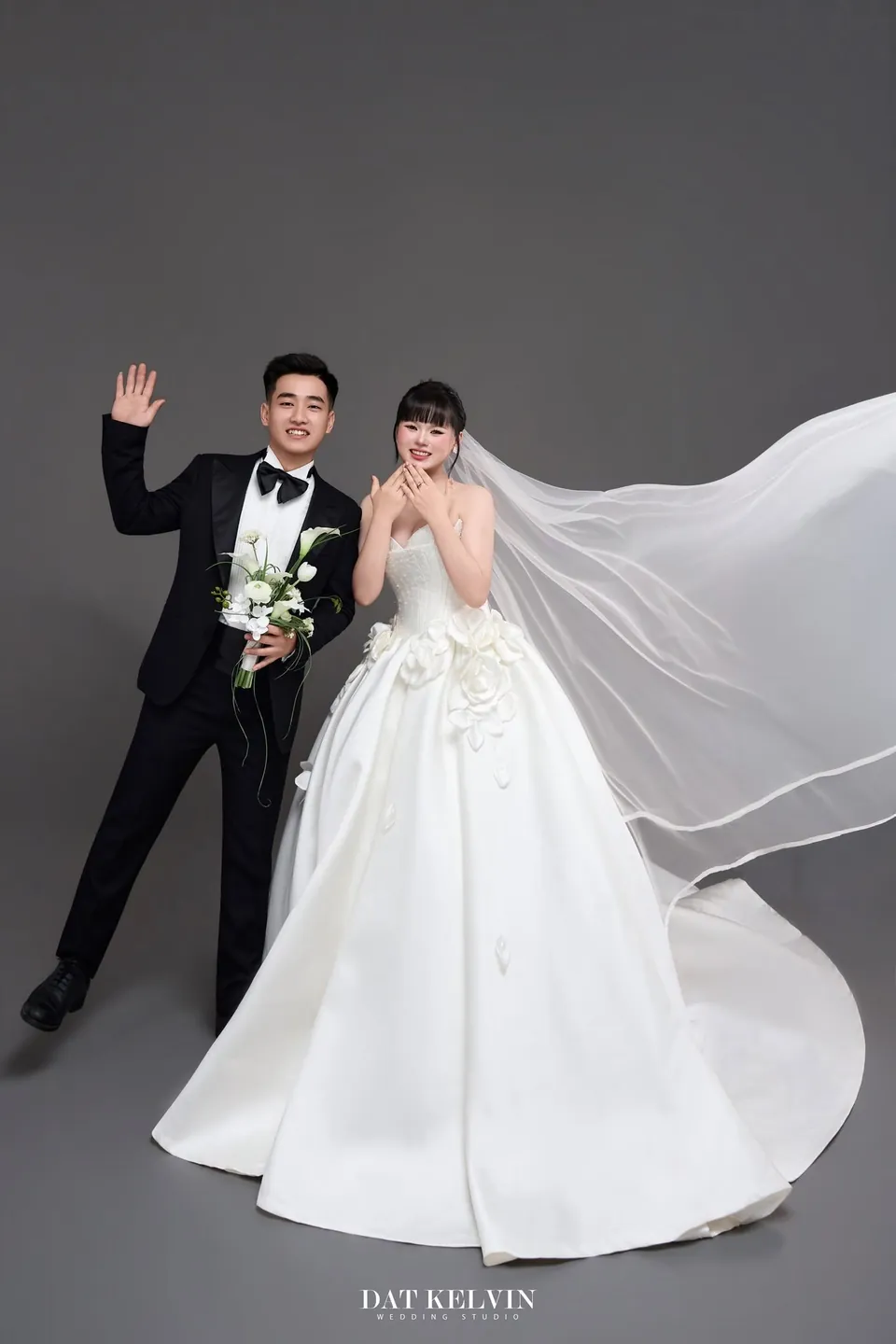 Cô dâu và chú rể vẫy tay, khăn voan bay dài