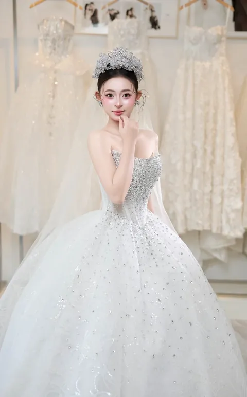 Cô dâu váy công chúa đính kết đứng giữa phòng váy cưới