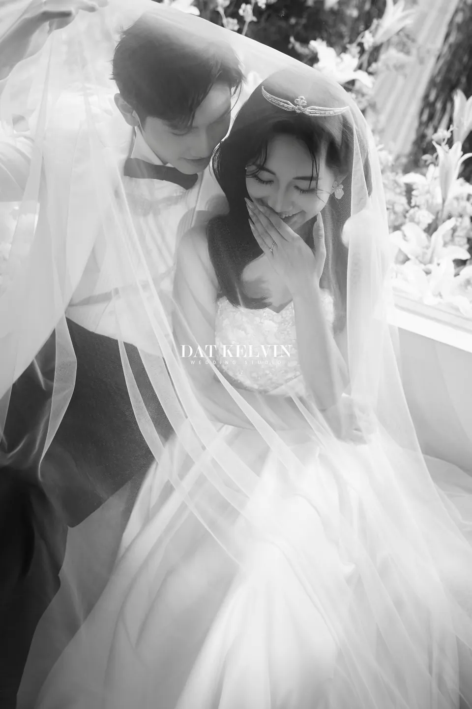 Ảnh đen trắng chú rể hôn cô dâu dưới khăn voan