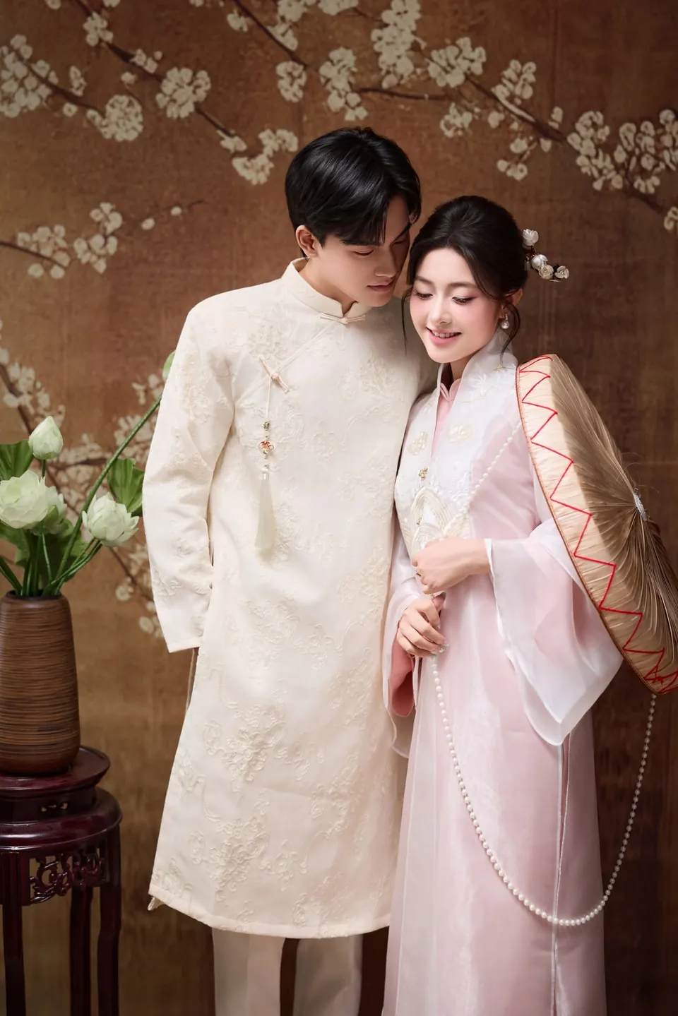 Cô dâu tựa vai chú rể, tay cầm nón, trong bộ ảnh cưới áo dài