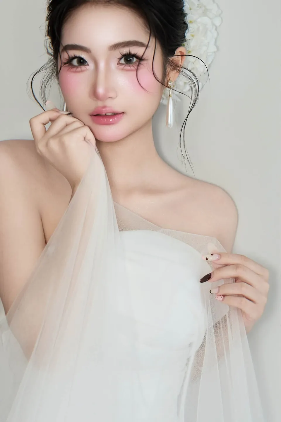 Cô dâu nghiêng đầu cầm khăn voan, lớp trang điểm trong trẻo